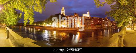 Vue panoramique sur les bâtiments colorés de Gérone au bord de la rivière et la cathédrale au crépuscule en Catalogne, Espagne. Banque D'Images