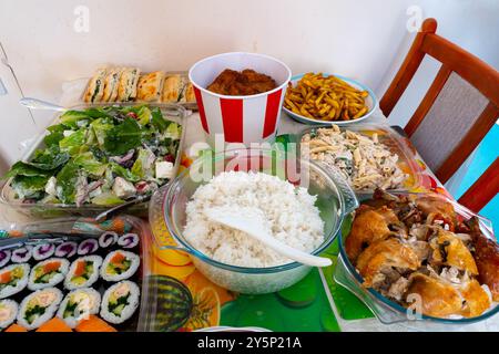 Une sélection de nourriture, un buffet pour une fête de famille comprenant un bac de poulet forme KFC sur une table Banque D'Images
