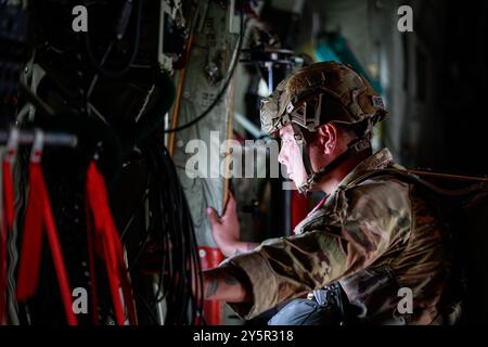 Un soldat de l'armée américaine appartenant à la 82e division aéroportée regarde par la fenêtre d'un Lockheed Martin C-130H avant d'effectuer des sauts de ligne statiques croisés pour Falcon Leap 24 à l'aéroport d'Eindhoven, Eindhoven, pays-Bas, le 19 septembre 2024. Falcon Leap 24 (FALE 24) est un exercice aéroporté technique conjoint multinational dirigé par l'armée royale néerlandaise, conçu pour améliorer l'interopérabilité des forces aéroportées et des équipages aériens participants de l'OTAN dans les opérations de parachutisme de personnel et d'équipement à Arnhem, aux pays-Bas, du 9-20 au 30 septembre 2024. Falcon Leap est le plus grand exercice aéroporté technique de l'OTAN Banque D'Images