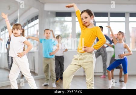 Fille apprendre à danser des danses modernes, faire du mouvement avec un professeur méconnaissable. Banque D'Images