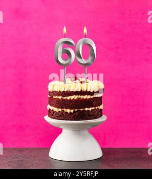 Gâteau de velours rouge - numéro d'anniversaire 60 sur fond rose. Banque D'Images