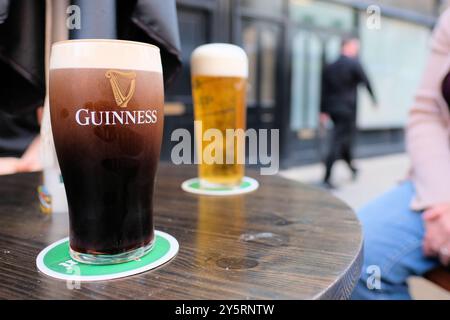 Un verre de marque de bière Guinness stout avec une tête de mousse crémeuse au magasin Guinness à un James Gate à Dublin, Irlande ; logo de harpe Brian Boru. Banque D'Images