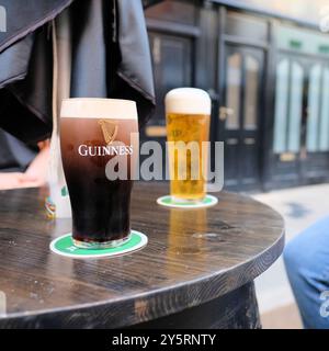 Un verre de marque de bière Guinness stout avec une tête de mousse crémeuse au magasin Guinness à un James Gate à Dublin, Irlande ; logo de harpe Brian Boru. Banque D'Images