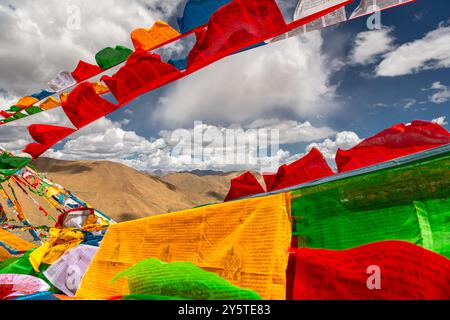 SHIGATSE, TIBET - 1er AOÛT 2022 : des drapeaux de prière tibétains colorés flottent au sommet du col de Kardung la en Inde, l'un des plus hauts cols de montagne motorisables Banque D'Images