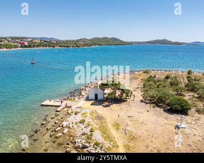 Pakostane, Croatie - 27 juillet 2024 : petite île avec petite chapelle près de la ville de Pakostane en Croatie Banque D'Images