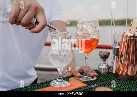 Cocktails rafraîchissants servis au bord de l'eau avec glace et garnitures. Banque D'Images