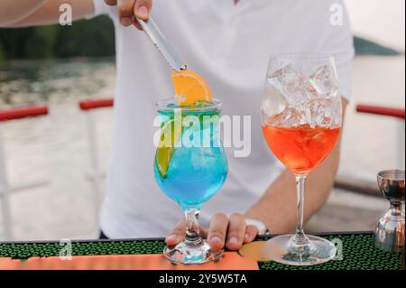 Cocktails rafraîchissants servis par un Bartender sur une terrasse panoramique extérieure. Banque D'Images