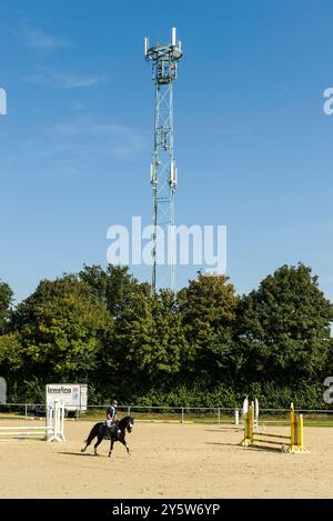 Mobilfunkmât überragt Reitplatz, sorgt für Empfang auf dem Land. 20240922ad293 antenne, Dorf, Drahtlos, Empfang, Funknetz, Infrastruktur, Landschaft, Ländlich, Mast, Mobilfunk, Netzabdeckung, Pferde, Reitplatz, Reitsport, signalisation, technologie, Telekommunikation, Verbindungen, Versorgung, Wetter, sans fil, Zelle, Zukunft Wadersloh Nordrhein-Westfalen NRW Deutschland Allemagne *** téléphone portable tours de mât sur l'arène d'équitation, assure la réception dans la campagne 20240922ad293 antenne, village, sans fil, réception, réseau radio, infrastructure, paysage, rural, mât, radio mobile, couverture réseau Banque D'Images