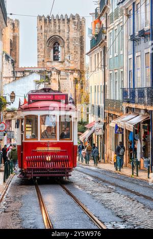 Lisbonne, Portugal - 19 septembre 2024 : vieux tramway ou tramway conduisant dans la vieille ville. Les gens sont dehors et en déplacement dans le célèbre endroit. Banque D'Images