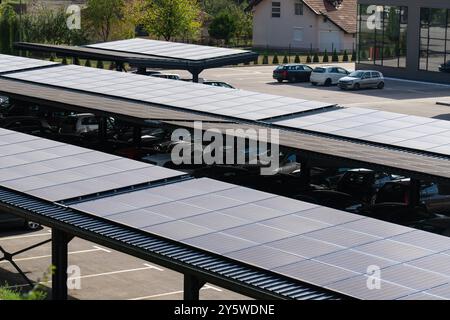 Place de parking avec panneaux solaires sur un toit. Banque D'Images