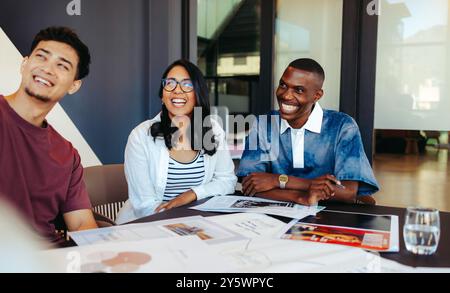 Camarades de classe multiethniques profitant d'une session d'étude heureuse et engageante ensemble, favorisant la créativité et le travail d'équipe dans un environnement de classe moderne. Banque D'Images