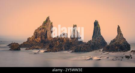 Une photographie 2:1 d'un lever de soleil brumeux sur la plage de Gueirua, une petite baie de galets qui est remarquable pour ses beaux paysages. À l'extrémité est de la plage, Banque D'Images