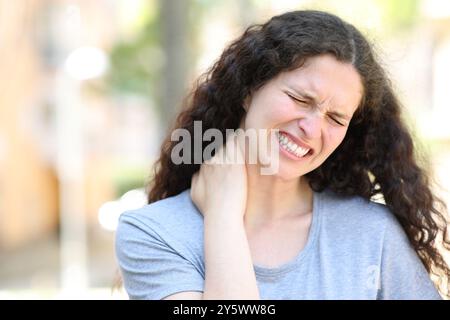 Femme dans la rue souffrant de fibromyalgie et se plaignant Banque D'Images