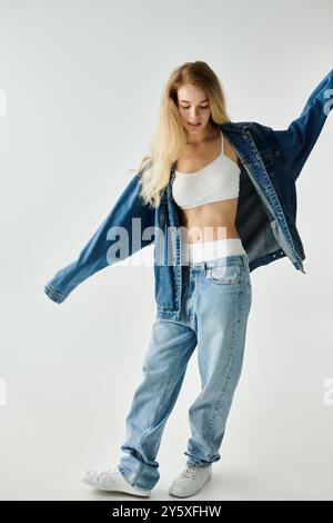 Une jeune femme vibre gracieusement en denim surdimensionné, mettant en valeur le style sans effort et la confiance. Banque D'Images