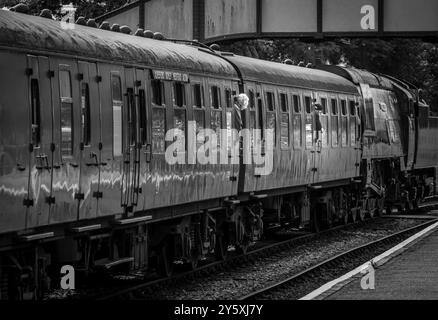 Photo en noir et blanc d'un train attendant de partir de la gare de Ropley, où se trouve la Watercress line, Hampshire, Angleterre. Banque D'Images