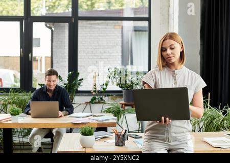 Deux collègues s’engagent dans une séance productive, entourés de plantes et d’un design d’espace de travail inspirant. Banque D'Images