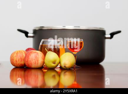 Verre de cidre aux fruits avec quelques fruits et Stockpot. Arrière-plan lumineux Banque D'Images