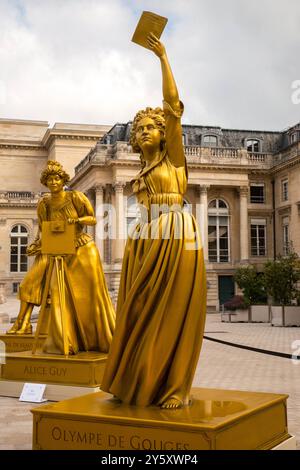 Les statues des 'dix femmes d'or' révélées lors de la cérémonie d'ouverture des Jeux Olympiques de Paris 2024 ont pris place dans la Cour d'honneur de l'Assemblée nationale, où elles sont exposées jusqu'au 5 octobre dans le cadre d'une exposition gratuite. Dix grandes statues dorées représentant des femmes qui ont marqué l’histoire de France (Olympe de Gouges, Alice Milliat, Gisèle Halimi, Simone de Beauvoir, Paulette Nardal, Jeanne Barret, Louise Michel, Christine de Pizan, Alice Guy et Simone Veil) dans les domaines de la science, de l'art, de la littérature, de la politique ou du sport, accompagnés d'attributs (blouse d'avocat Banque D'Images