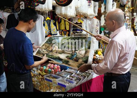 (240923) -- KASHGAR, 23 septembre 2024 (Xinhua) -- Un touriste choisit des tapis de laine dans l'ancienne ville de Kashgar, région autonome ouïgur du Xinjiang, au nord-ouest de la Chine, 19 septembre 2024. L'ancienne ville de Kashgar, située dans le sud-ouest du Xinjiang, a servi de plaque tournante de transport vitale reliant la Chine à l'Asie centrale et à l'Asie du Sud dans les temps anciens. La confluence de diverses cultures ethniques dans cette région a donné naissance à une richesse de trésors historiques et culturels. Aujourd'hui, Kashgar a exploité ses avantages culturels et géographiques, se transformant en une destination touristique unique qui blen Banque D'Images