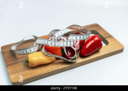 Planche à découper avec des légumes et un ruban à mesurer. Concept de régime alimentaire et perte de poids. Photo de haute qualité Banque D'Images