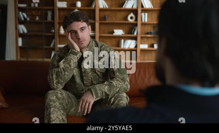 Triste client caucasien réfléchi homme déprimé militaire soldat homme officier en uniforme de combat Guy défenseur tenant la tête souffrant de dépression TSPT Banque D'Images