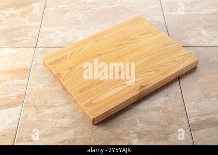 Planche à découper sur une table de cuisine. Fond culinaire. Planche à découper en bois vide, espace d'affichage du produit. Banque D'Images