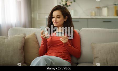 Souriant femme caucasienne client heureux femme acheteur fille femme d'affaires utilisant le téléphone portable tenant la carte bancaire de crédit faisant la banque de paiement en ligne Banque D'Images