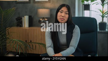 Jeune femme asiatique parle de conflit familial, discute des problèmes relationnels lors de la consultation avec un psychothérapeute. Au premier plan, le psychologue non focalisé écoute le patient pendant la thérapie de couple. Banque D'Images