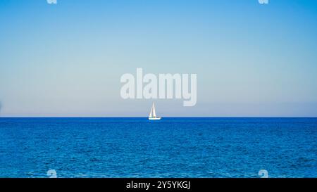Voilier solitaire à l'horizon de la mer Banque D'Images
