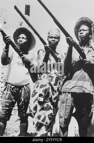 Région de la Volta, Afrique occidentale française. Ces Amazones robustes de la Volta, habillés comme leurs maris de guerre, montrent leur habileté à tirer avec d'anciens mousquets lors d'une récente intallation d'un chef tribal ici. Autrefois, lorsque la guerre intertribale féroce était courante, les femmes de la région se battaient côte à côte avec leur menfolk. 10 AVRIL 1961 Banque D'Images