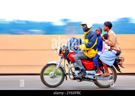 Un taxi moto connu sous le nom de boda boda transportant des passagers à Kampala Ouganda Banque D'Images