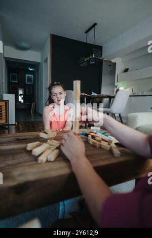 Enfant exprimant la frustration pendant le jeu de société familial dans le salon confortable Banque D'Images