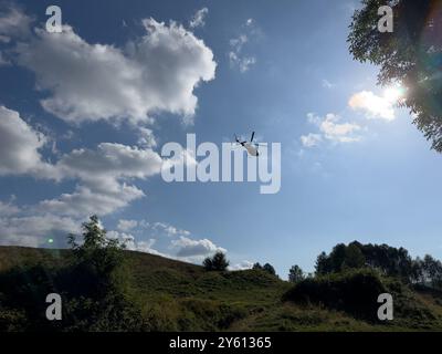 Un hélicoptère transportant un colis dans les montagnes du lac de Côme, en Italie Banque D'Images