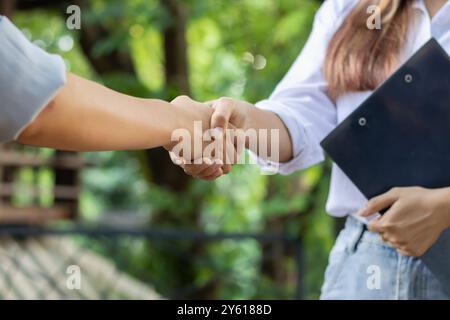 La jeune femme d’affaires a serré la main à des conseillers juridiques après avoir rédigé un contrat à signer par les investisseurs et à assurer la légitimité. Idée commerciale avec Banque D'Images
