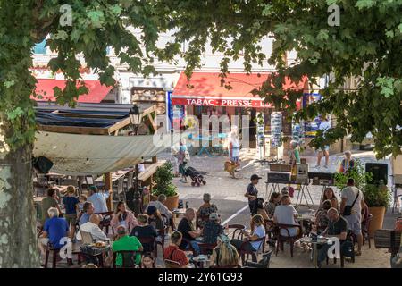 Les gens se détendent dans un Bar pendant le marché hebdomadaire à Dieulefit, Drome, Sud-est de la France. Banque D'Images
