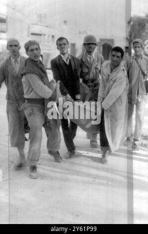 DES SAUVETEURS TRANSPORTANT UN SURVIVANT À LA SUITE DU TREMBLEMENT DE TERRE D'AGADIR LE 2 MARS 1960 Banque D'Images