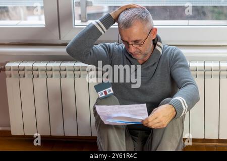 Homme mûr inquiet d'un prêt hypothécaire. Dette hypothécaire, prêt immobilier. Problèmes de remboursement de la dette dans les institutions financières Banque D'Images