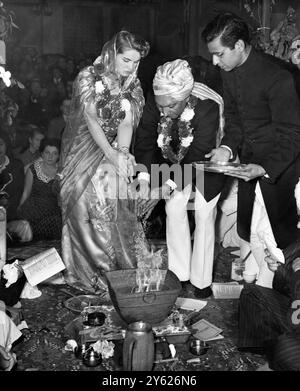 La mariée vêtue de sari , l'infirmière irlandaise Mlle Sadie Durkin , et le marié turbanné , propriétaire du restaurant M. Shri Dharam Chand Wadhwa , jetèrent de l'encens sur le feu lors de leur mariage , avec cérémonie hindoue , dans les salles Mayfair à Marylebone , Londres . La cérémonie a eu lieu à l'autel d'un temple hindou imitant construit dans leurs chambres le .26 septembre 1954 Banque D'Images