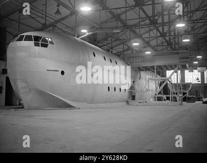 Le plus grand vol - les bateaux jamais construits en Grande-Bretagne prennent lentement forme à l'usine Cowes, IOW de Saunders-Roe, Ltd. L'avion de 100 places, dont trois sont en construction, est le S.R.45. Chacun aura un poids total de plus de 130 tonnes et aura une longueur de 150 pieds. Au début des années 1950, ces navires sont prévus pour fournir un service de luxe de 300 m.p.h. sans escale à travers l'Atlantique Nord. Les trois hydravions ont déjà coûté environ trois quarts de million de livres et bien que des craintes aient été exprimées quant à l'avenir à la lumière de la BOAC l annoncée récemment Banque D'Images