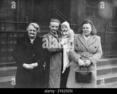 Vêtu d'un costume de laine bleu, Raymond Larry Ward, âgé de sept mois, d'Agar Grove, que le policier londonien a recherché pendant huit heures hier, après avoir été manqué de sa poussette, a dormi paisiblement chez sa grand-mère, au tribunal de première instance de Clerkenwell aujourd'hui. Sa mère, Mme Elsie Ward, a également été importante lorsque Muriel Locke, 19 ans, de Nathanial Road, Devonshire, a été accusée d'avoir emmené Raymond à Rochester Square hier. Images : Raymond est assis serré dans les bras de son père (au centre) avec sa mère (à droite) et sa grand-mère. 9 janvier 1948 Banque D'Images