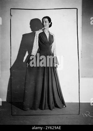 Le clou de la foire et du bal United Charities organisé à l'hôtel Dorchester, Londres, a été aujourd'hui un défilé de mannequins organisé par le Secrétariat international de la laine. De nombreuses créations nouvelles et attrayantes étaient exposées. Images montrent : cette maison dramatique cramoisie et en laine blanche a été un révélateur dans le défilé d'aujourd'hui. La jupe de balayage est complétée par les poignets en cloche ; les manches et les épaules sont fortement brodées. 24 novembre 1947 Banque D'Images