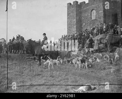 Les villageois se montrent en force pour voir les quatre Burrows Foxhounds s'assembler au pittoresque château de Carn Brea, près de Redruth, en Cornouailles, pour la rencontre Snnual Boxing Day. Le maître, M. G. P. Williams est vu avec la meute de 22 couples de chiens dans l'ombre du château, situé au sommet de Carn Brea, qui domine cette partie de Cornouailles. 26 décembre 1947 Banque D'Images