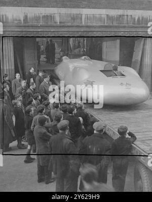 Les jeunes visiteurs de l'exposition des écoliers, qui ouvre ses portes dans le nouveau hall horticole de Westminster, verront la chose la plus rapide sur quatre roues - la fierté de M. John Cobb's Railton Mobil Special-Holding. La voiture géante dans laquelle M. Cobb a relevé le record du monde de vitesse terrestre à Bournville, Utah, en septembre dernier, est équipée de deux moteurs suralimentés Napia - Lion Aero. Spectacles de photos : une foule intéressée regarde la voiture géante emmenée dans Horticultural Hall aujourd'hui. M. John Cobb (chapeau Trilby noir) près de la voiture, supervise les opérations. 29 décembre 1947 Banque D'Images