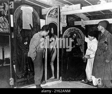 Butin de guerre nazi dans les mines de sel d'Altaussee , Autriche . Une caverne spéciale, la Mineralienkammer, a été aménagée pour protéger les panneaux de retable de Gand qui ont été prélevés dans la cathédrale Saint-Bavon. Le panneau 'Reine du ciel' est éclairé par Herr Sieber , le restaurateur de Berlin . Le panneau central de l'autel, ' L'Adoration de l'Agneau mystique ' était trop grand pour pénétrer dans les puits étroits et était entreposé près de l'atelier du restaurateur à l'embouchure de la mine 1945 Banque D'Images