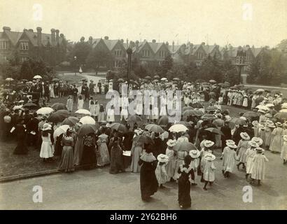 BOÎTE D'ARCHIVES 2 ARC 0033 D115 RÉFÉRENCE : 001334 JOURNÉE DES FONDATEURS À LA MAISON DU VILLAGE DES FILLES DATE : 1905 FILLES DANSANT SUR VERT VILLAGE : DAMES AVEC PARASOLS DR BARNARDO EN CHAPEAU HAUT À DROITE DU PIANO Banque D'Images