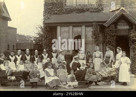 BOÎTE D'ARCHIVES 3 ARC 0088 D592 RÉFÉRENCE : 001389 MAISON DE VILLAGE DE FILLES : FILLES INVALIDES DATE : C 1890 GROUPE DE FILLES handicapées avec PERSONNEL DEVANT LE CHALET JAMES TYLER, Barkingside, Essex, Angleterre Banque D'Images