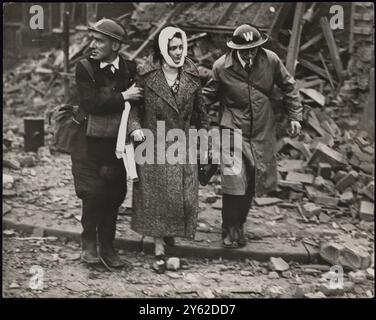 FEMME BLESSÉE QUAND LES MAISONS LONDONIENNES SONT BOMBARDÉES. LA PHOTO MONTRE:- une femme blessée, avec la tête bandée, aidée par des travailleurs de précautions de RAID aérien dans un quartier de Londres où des maisons ont été détruites par des raids de nuit allemands. 21 octobre 1940 CENSEUR N° 84539 Banque D'Images