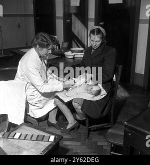 Avec la mise en place du Service national de santé en juillet 1948, cette jeune mère peut maintenant obtenir des soins de santé gratuits pour son bébé. Cela a aidé de nombreuses jeunes familles autour de la région de Bootle près de Liverpool dont la vie est gâchée par la pauvreté et les privations . Septembre 1948 Banque D'Images