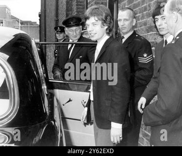 Trois membres du groupe pop Rolling Stones ont été reconnus coupables de comportement insultant et ont été condamnés à une amende de 5 £ chacun par le tribunal de première instance de Londres. Mick Jagger et Bill Wyman sont ici en train de quitter la Cour après l'audience. 22 juillet 1965 Banque D'Images