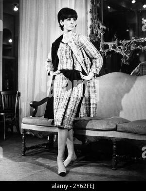 Paris : un ensemble signé Chanel montre un manteau élancé avec quatre poches plaquées dans un tweed délicat combinant plusieurs nuances de rose et de violet mouchetées aux bords blancs et doublées de sourate noire. Ceci est porté sur une robe droite , sans manches , avec la ceinture sourate noire douce et l'arc . Vu à la collection printemps et été 1965 . 6 février 1965 Banque D'Images